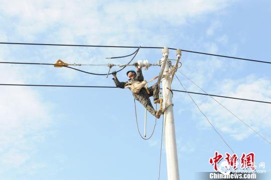 圖為該公司技術人員正解決農(nóng)村電網(wǎng)低電壓、“卡脖子”等用電難題?！≡櫭?攝