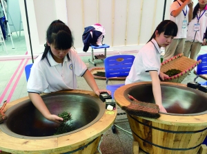 小姑娘肖曼（左）和同學(xué)正在炒茶 活動方供圖
